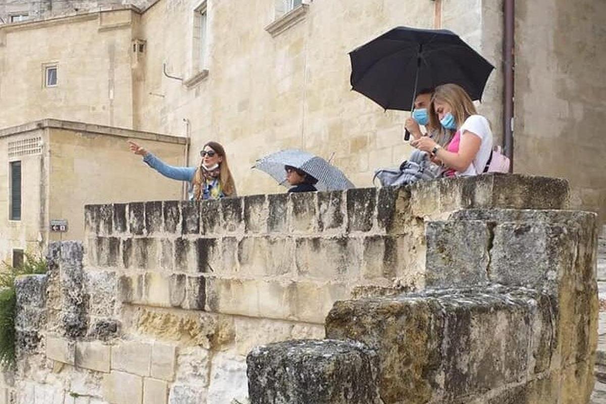 a group of people standing on a wall with umbrellas