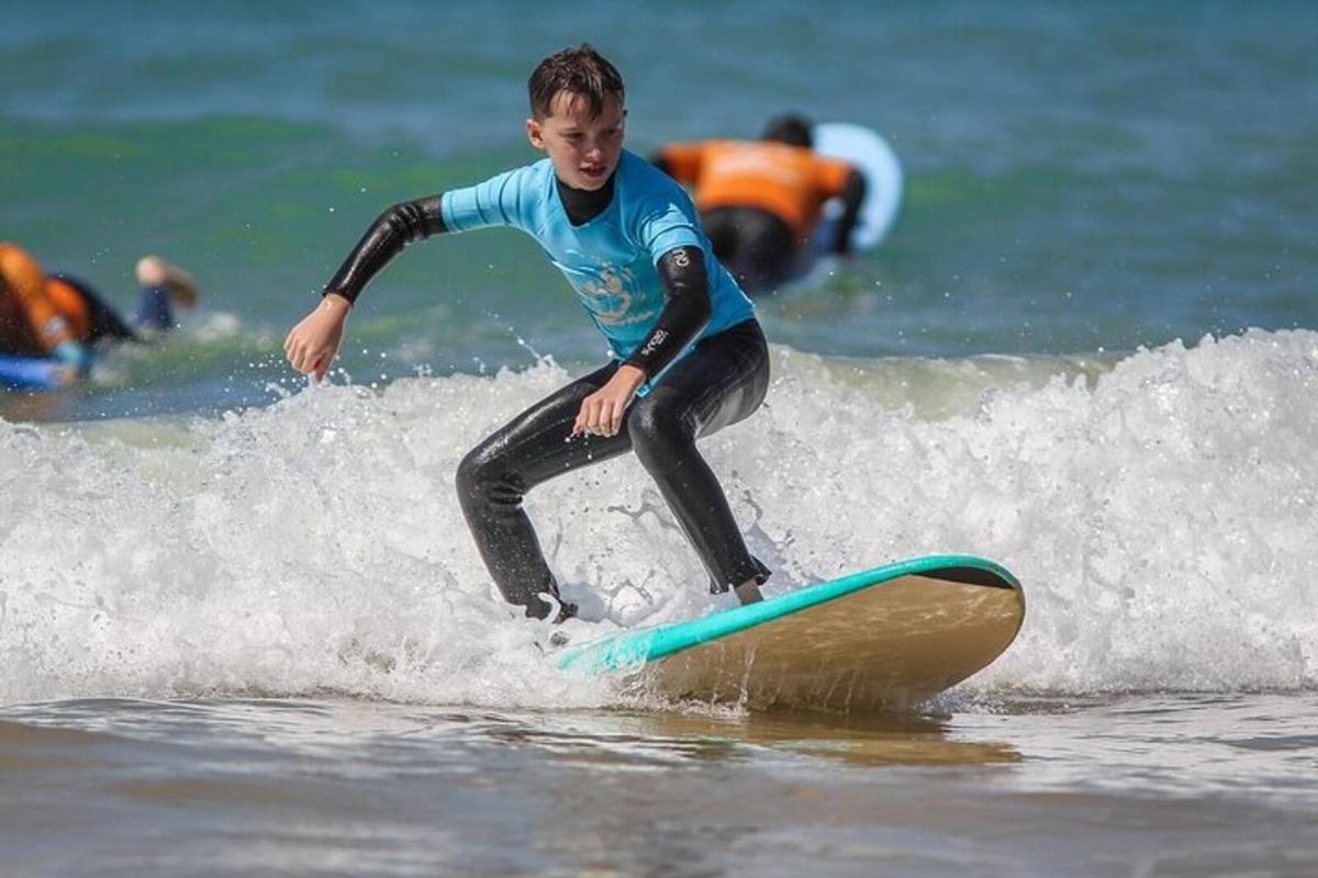 mladý chlapec jazdiaci na vlne na surfovej doske v oceáne
