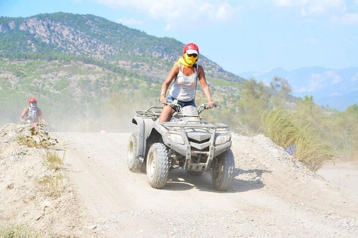 una persona que viaja en un vehículo de cuatro ruedas por un camino de tierra