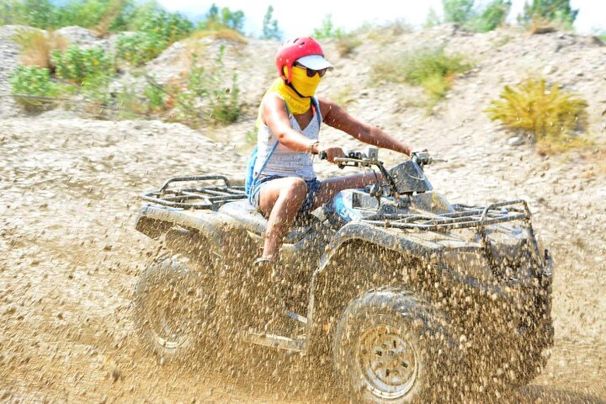 una persona che guida un quad nello sporco