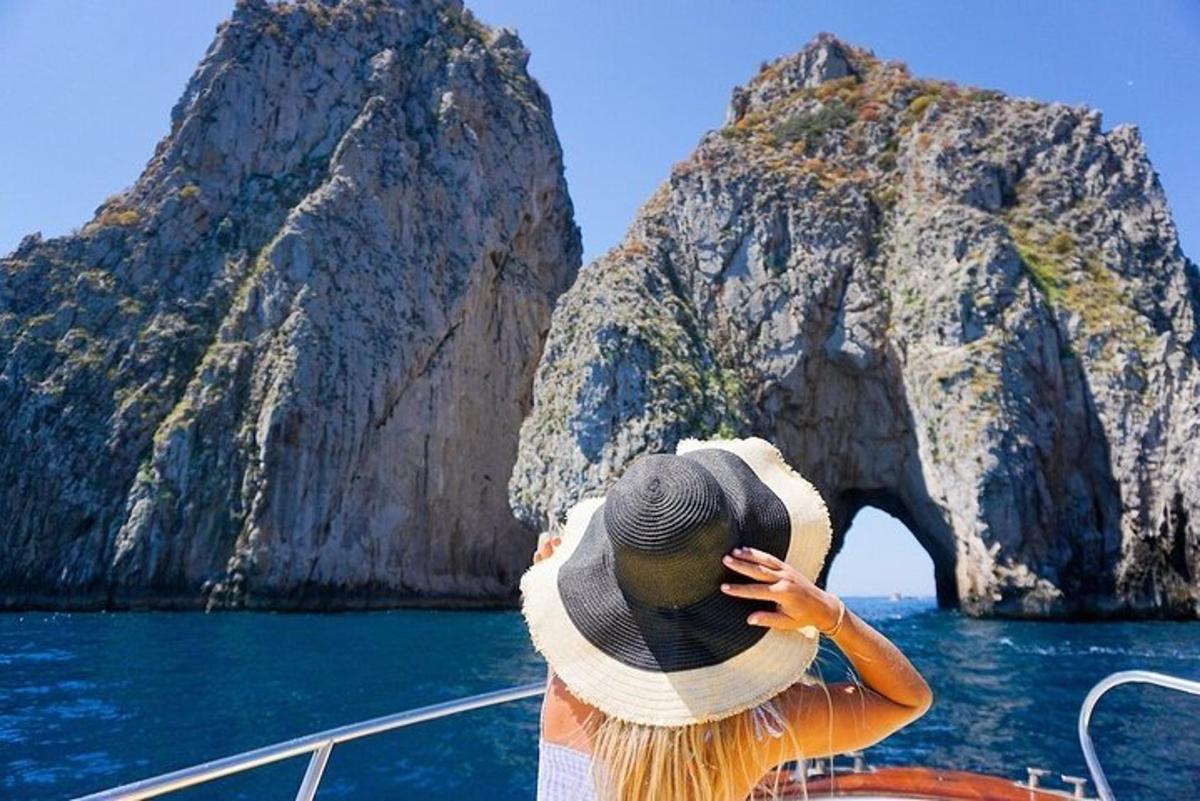 a woman on a boat looking at a rock formation
