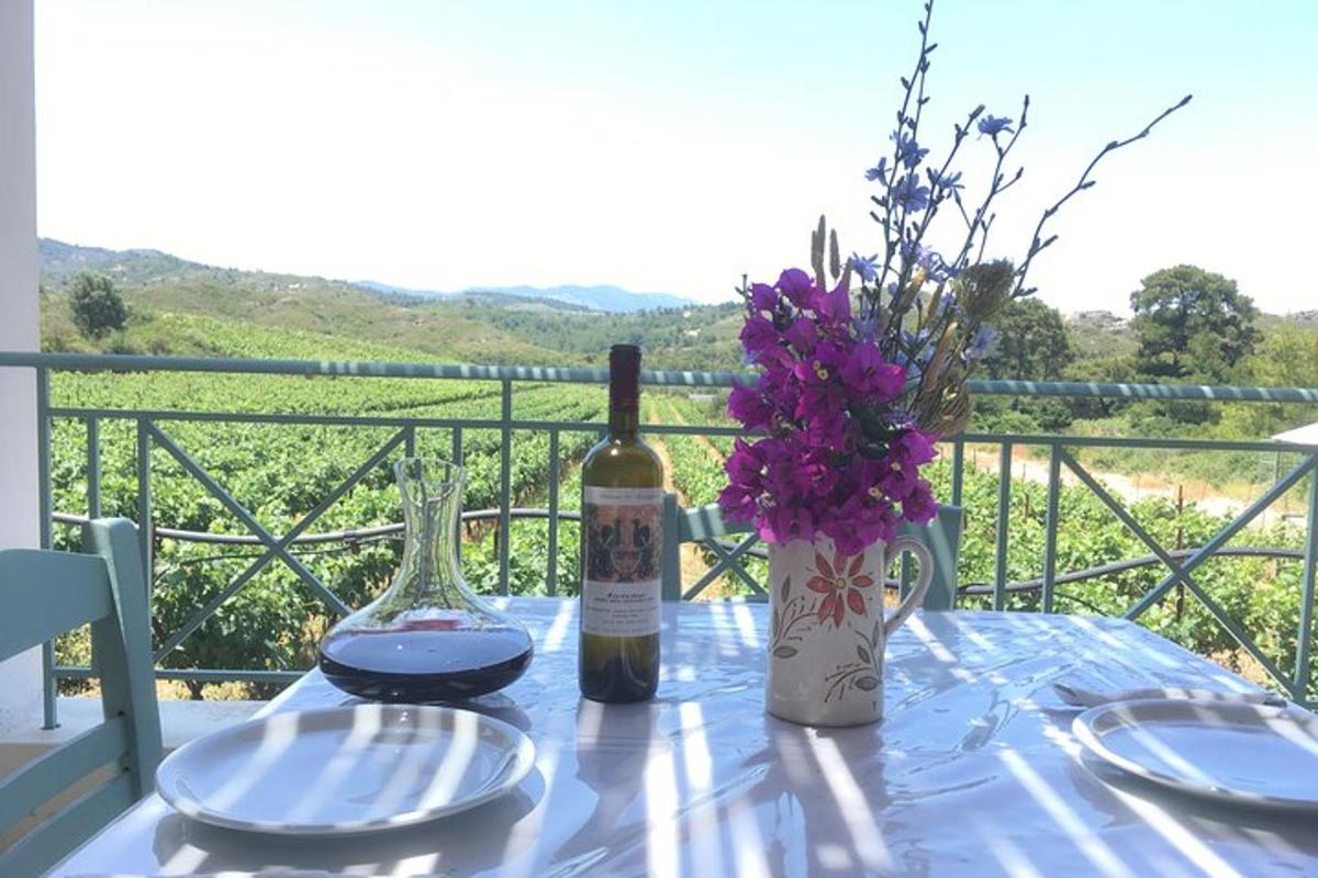Una mesa con una botella de vino y un jarrón de flores.