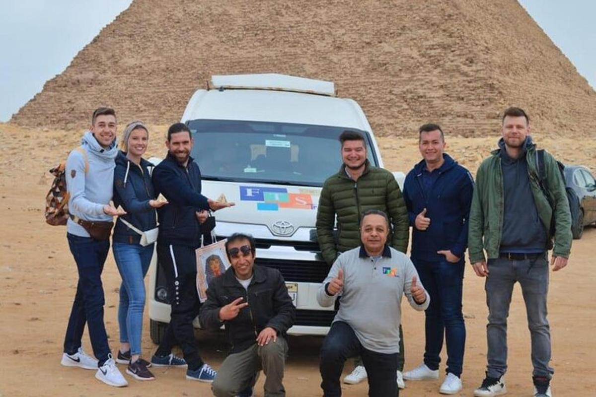 un gruppo di persone in piedi davanti a una piramide