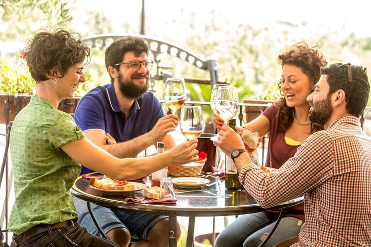 un gruppo di persone sedute attorno a un tavolo che bevono vino