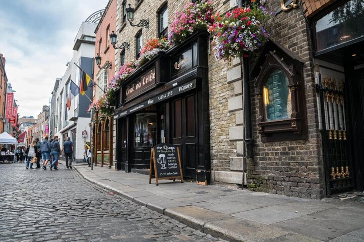 a cobblestone street next to a building with flowers