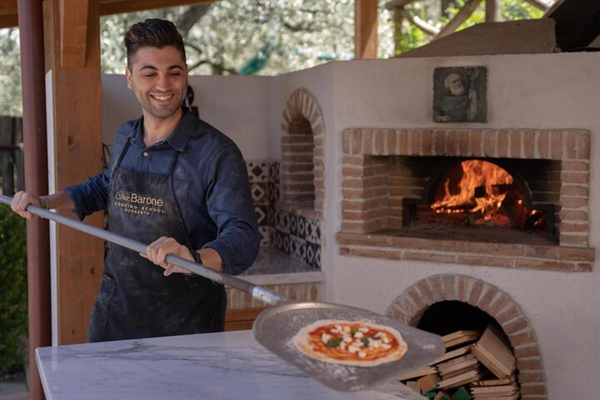 muž držící pizzu v peci na pizzu