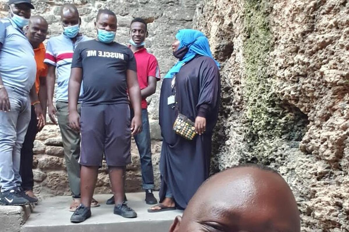 a group of people standing next to a stone wall