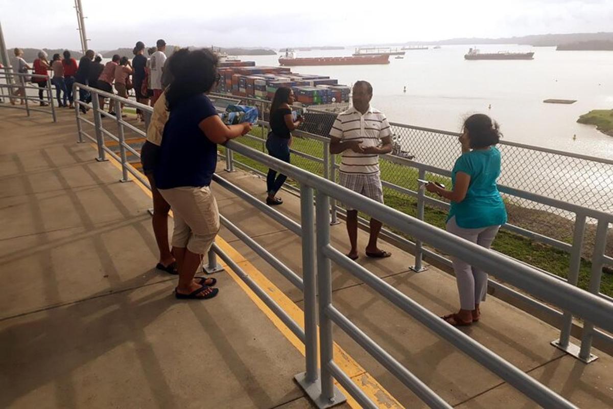 a group of people standing on a railing looking at the water