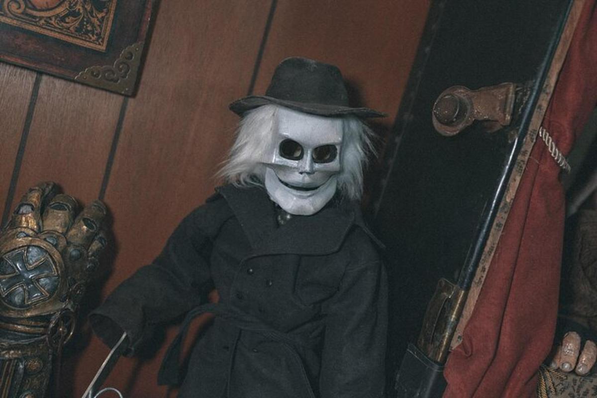 a clown in a suit and hat sitting in a door