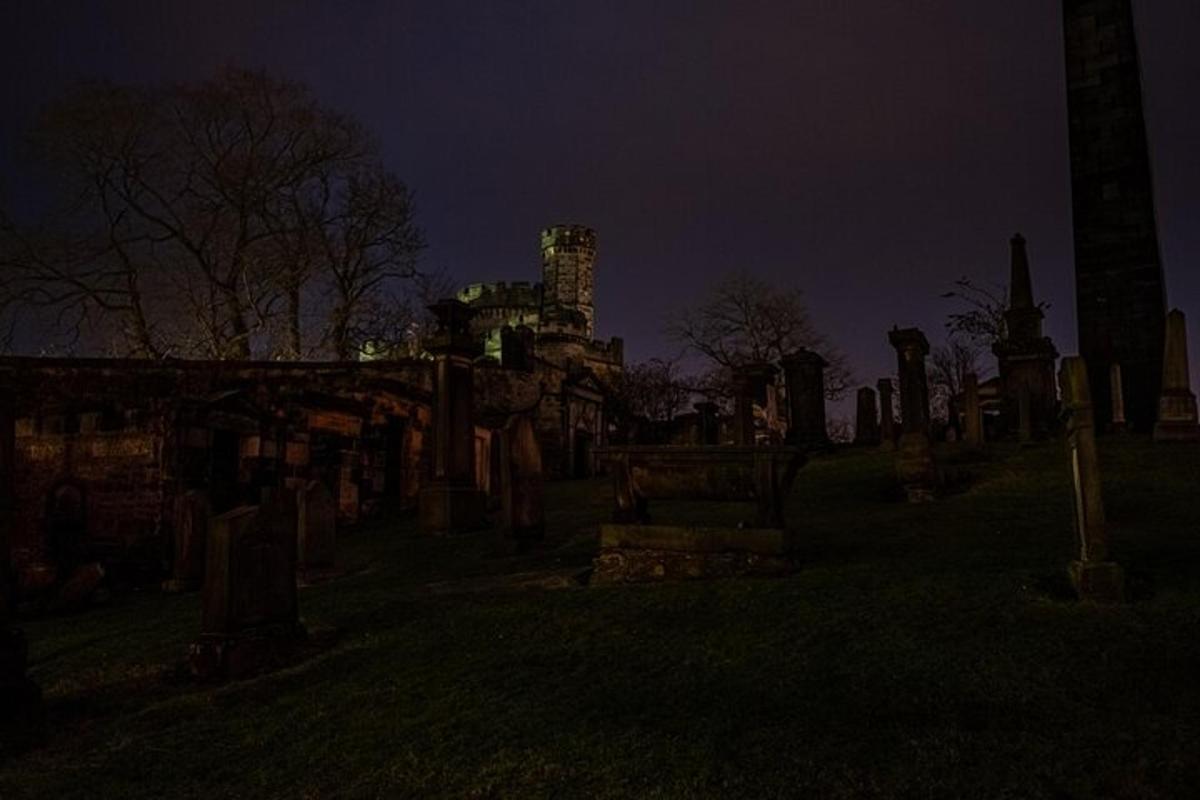 a cemetery at night with a castle in the background