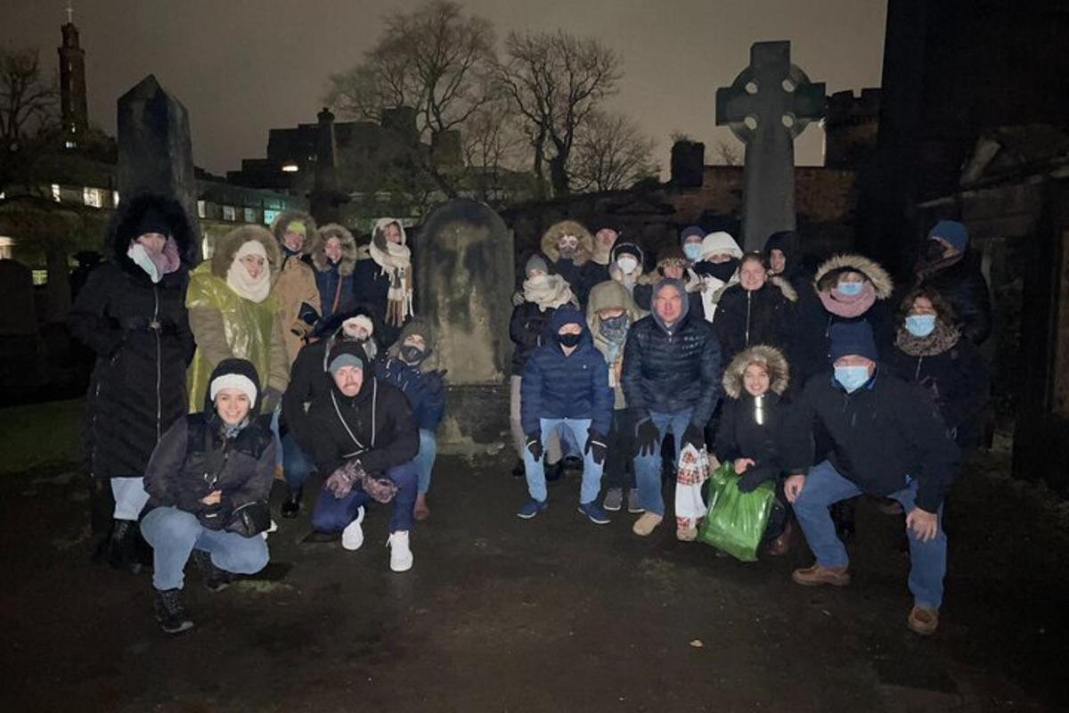 a group of people standing in front of a grave