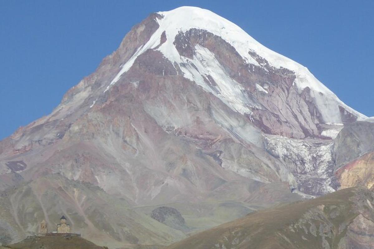 una montagna coperta di neve con un edificio di fronte
