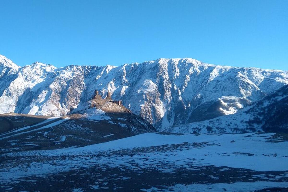 планина прекривена снегом са језером испред ње