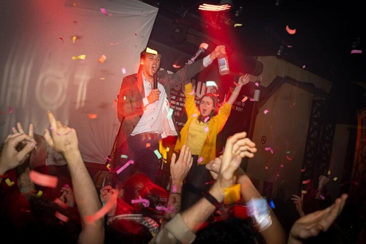 a group of people raising their hands in a nightclub