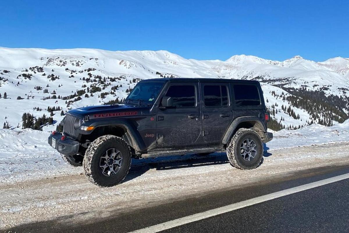 un jeep negru parcat pe marginea drumului