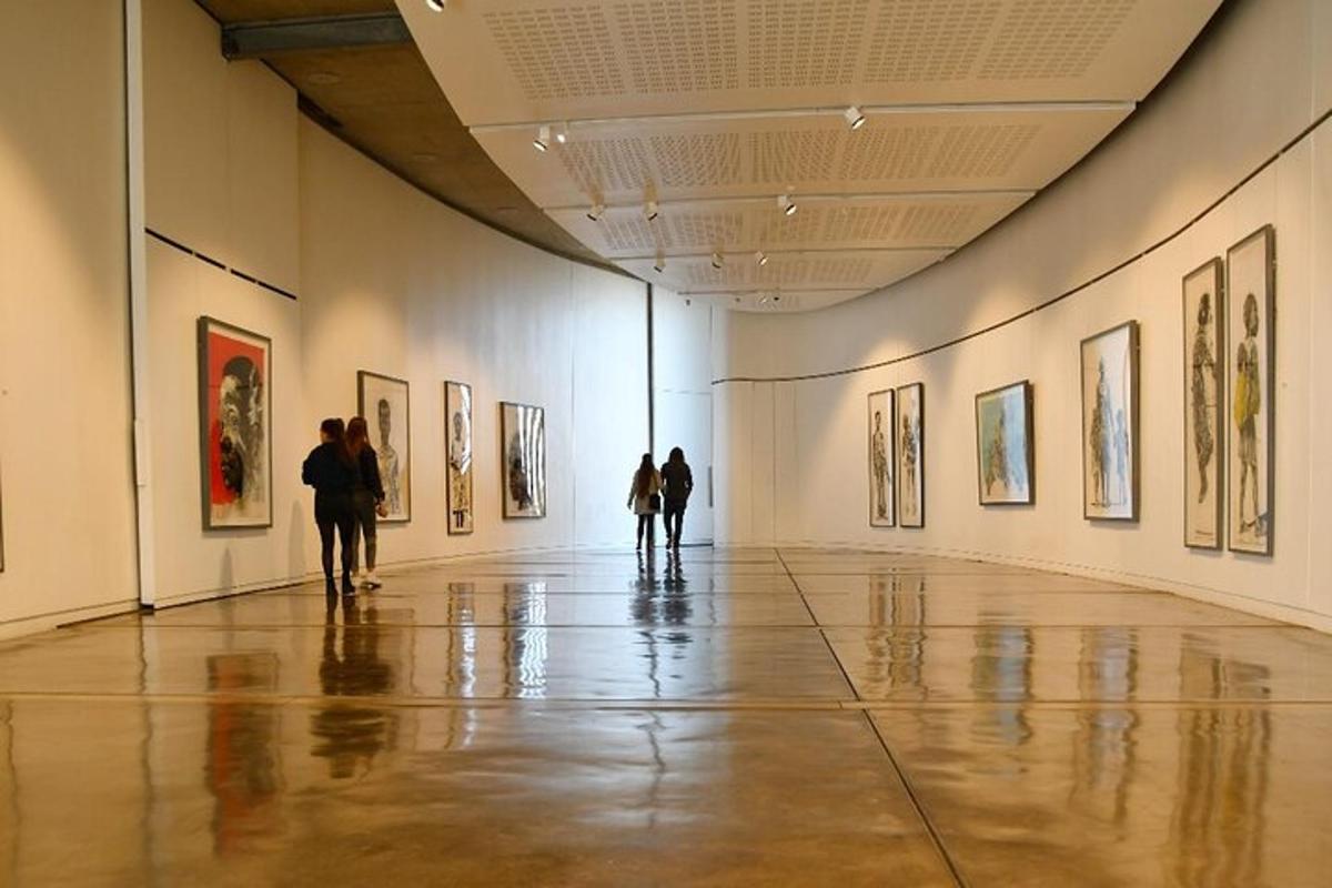 people standing in an art gallery looking at paintings