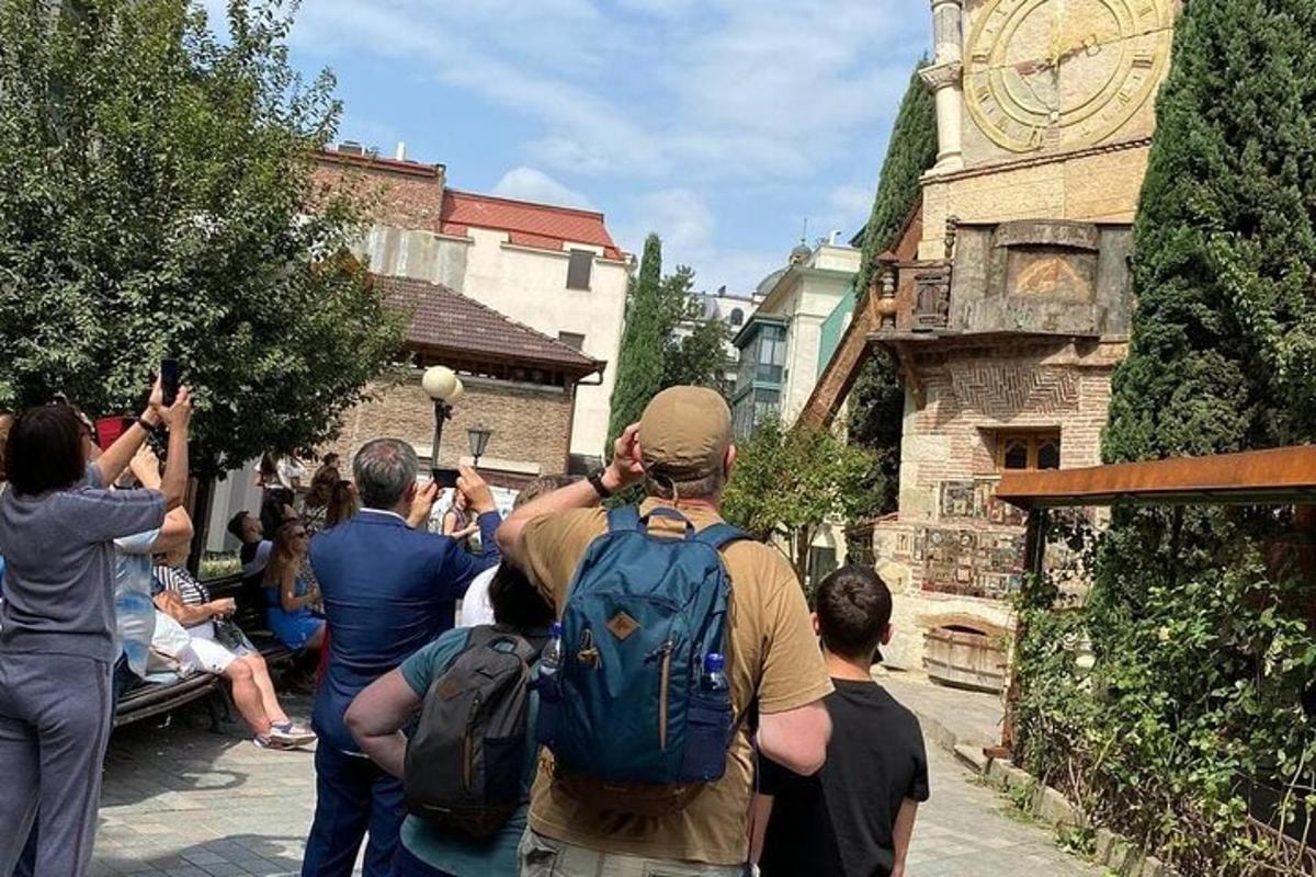 Un grupo de personas tomando fotografías de una torre de reloj.