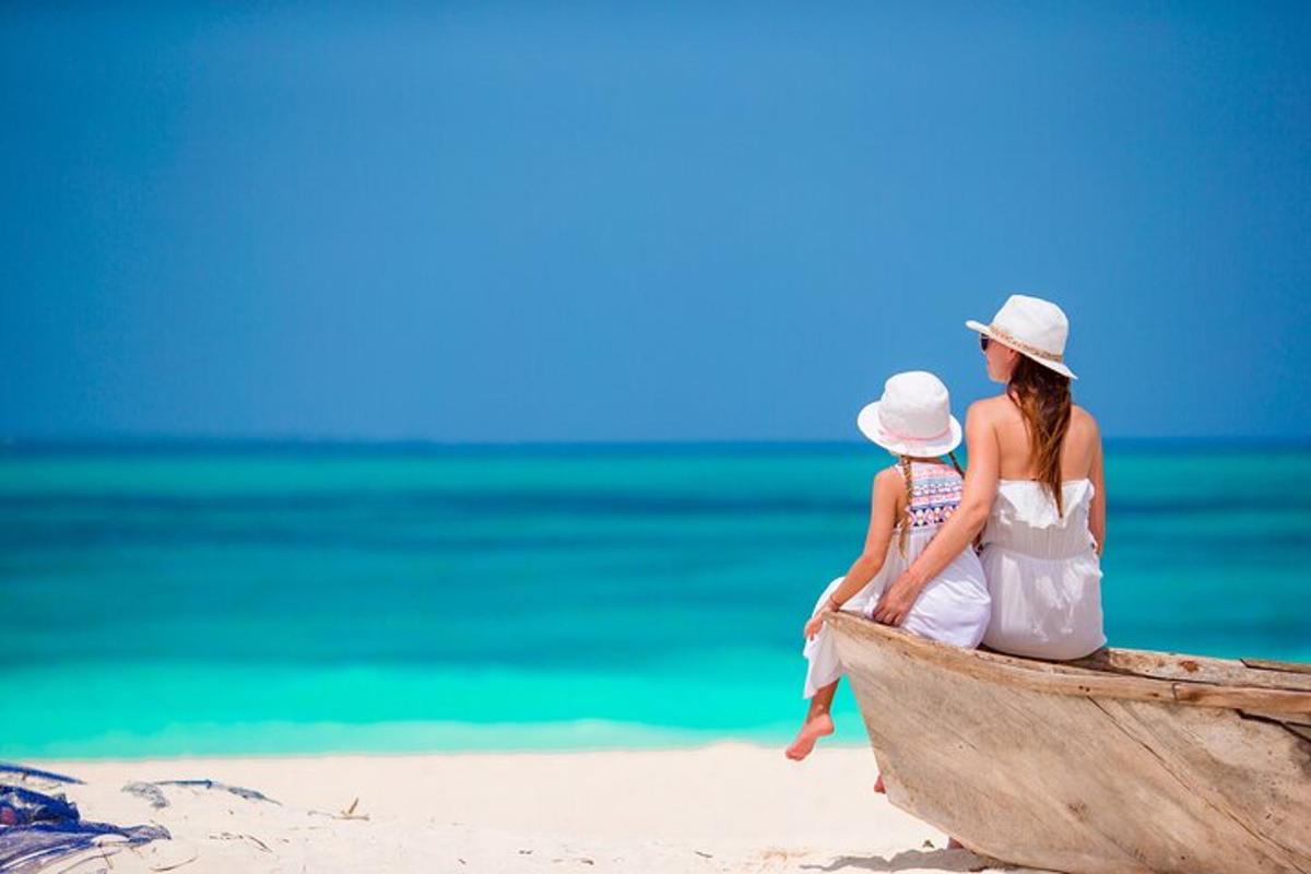 žena i dijete sjede u čamcu na plaži