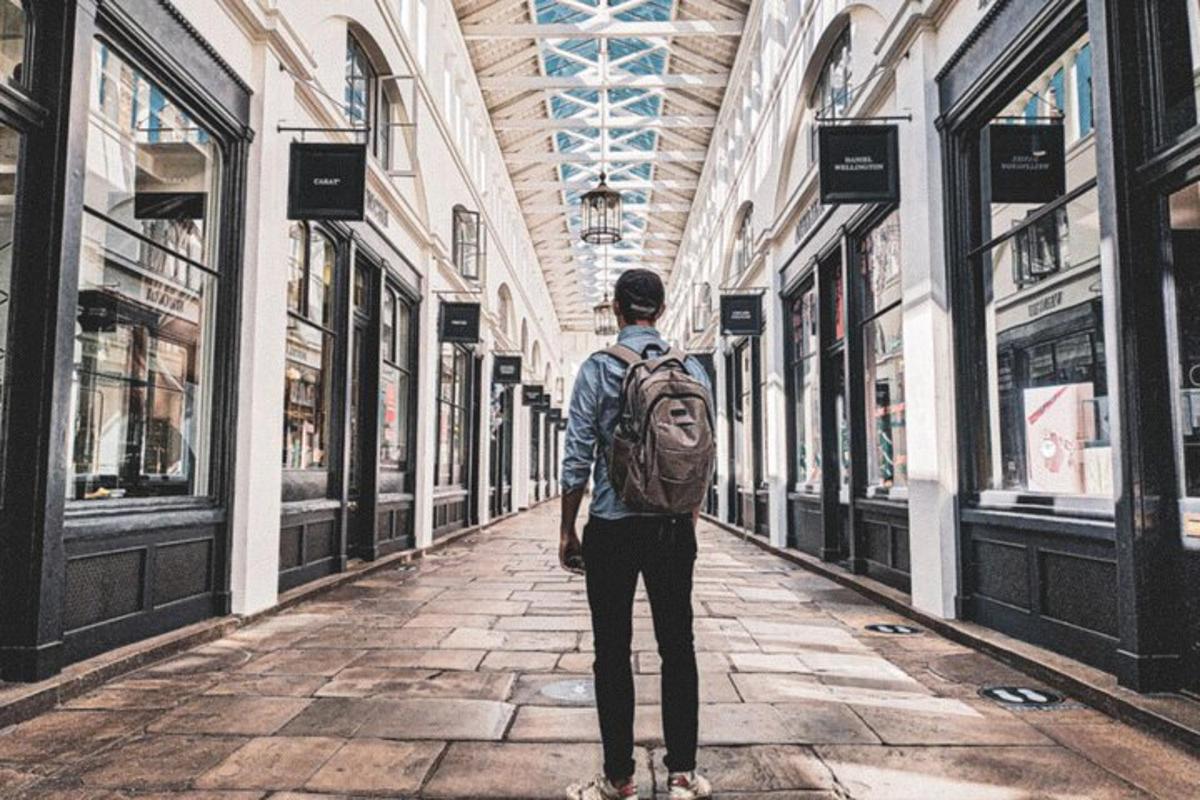 um homem com uma mochila caminhando por uma rua vazia
