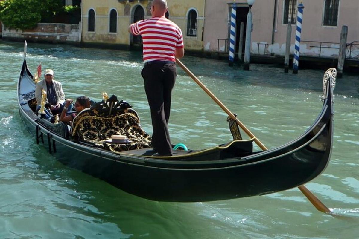 un uomo è in piedi in una gondola in acqua