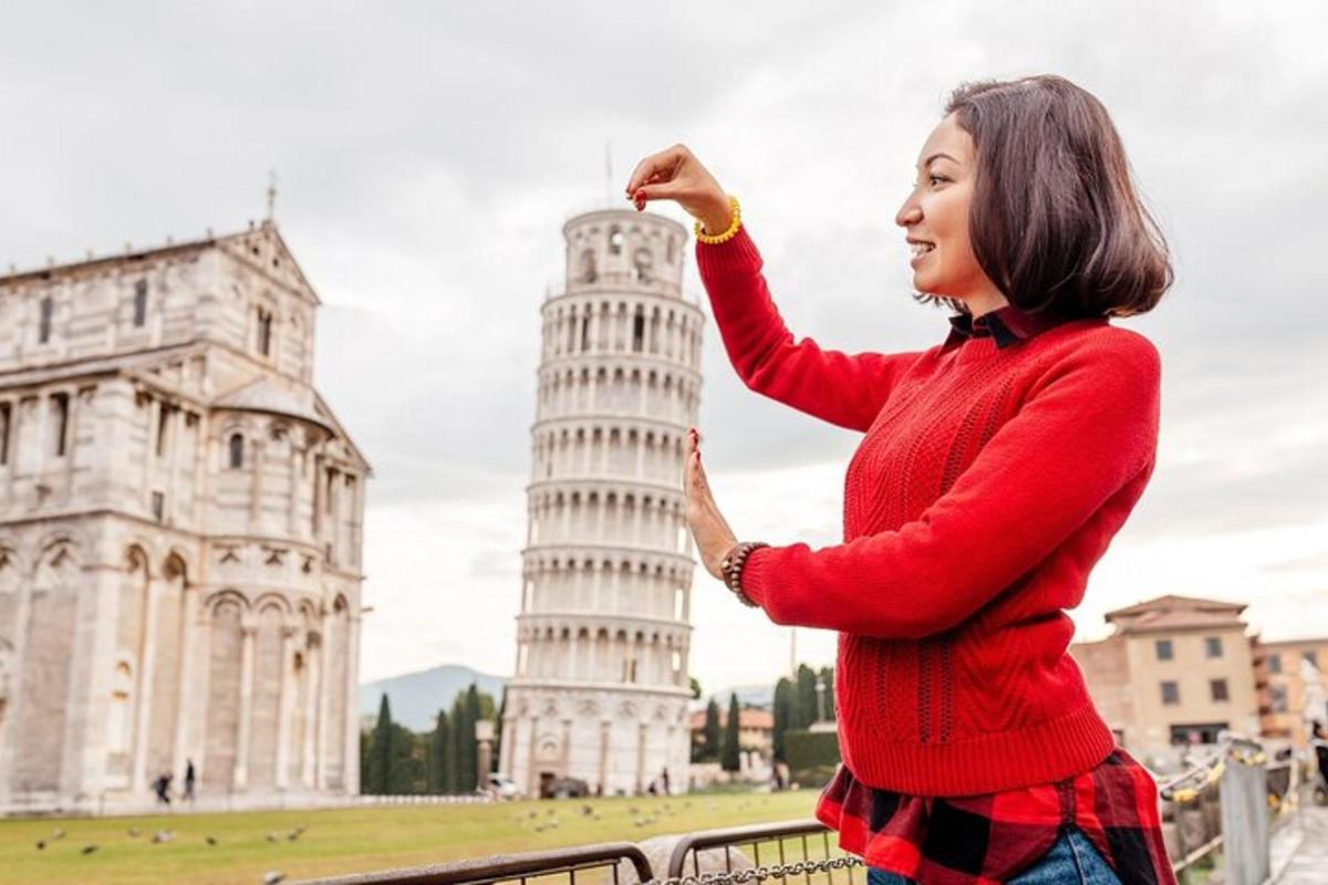 seorang wanita berdiri di hadapan menara pisa yang condong