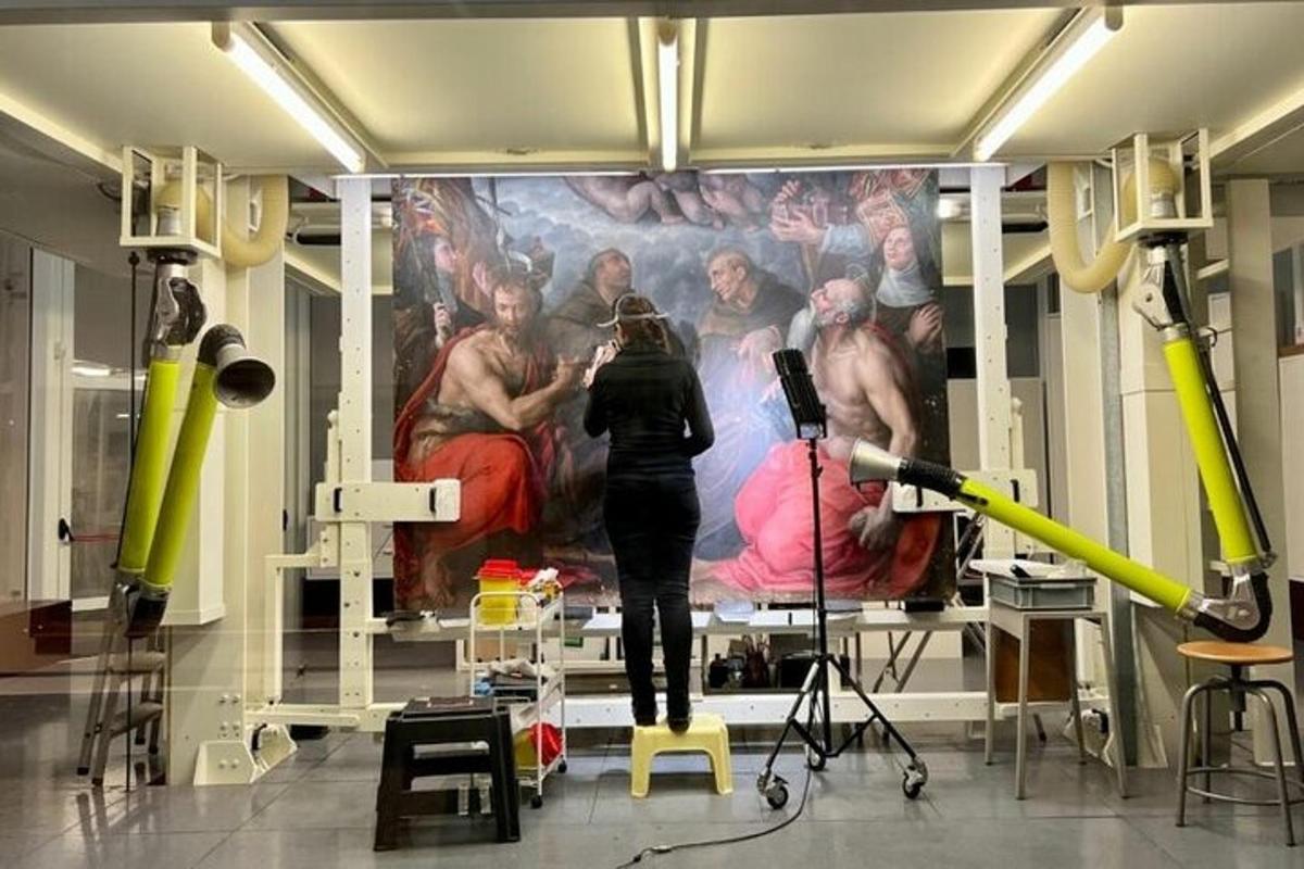 a woman taking a picture of a painting in a room
