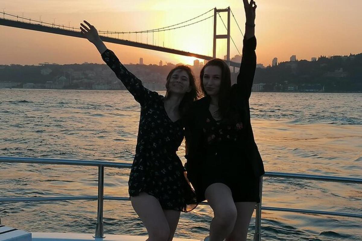 duas mulheres em pé em um barco em frente a uma ponte