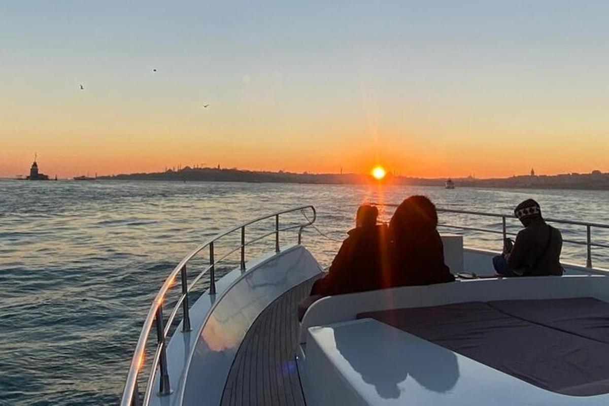 um grupo de pessoas sentadas em um barco ao pôr do sol