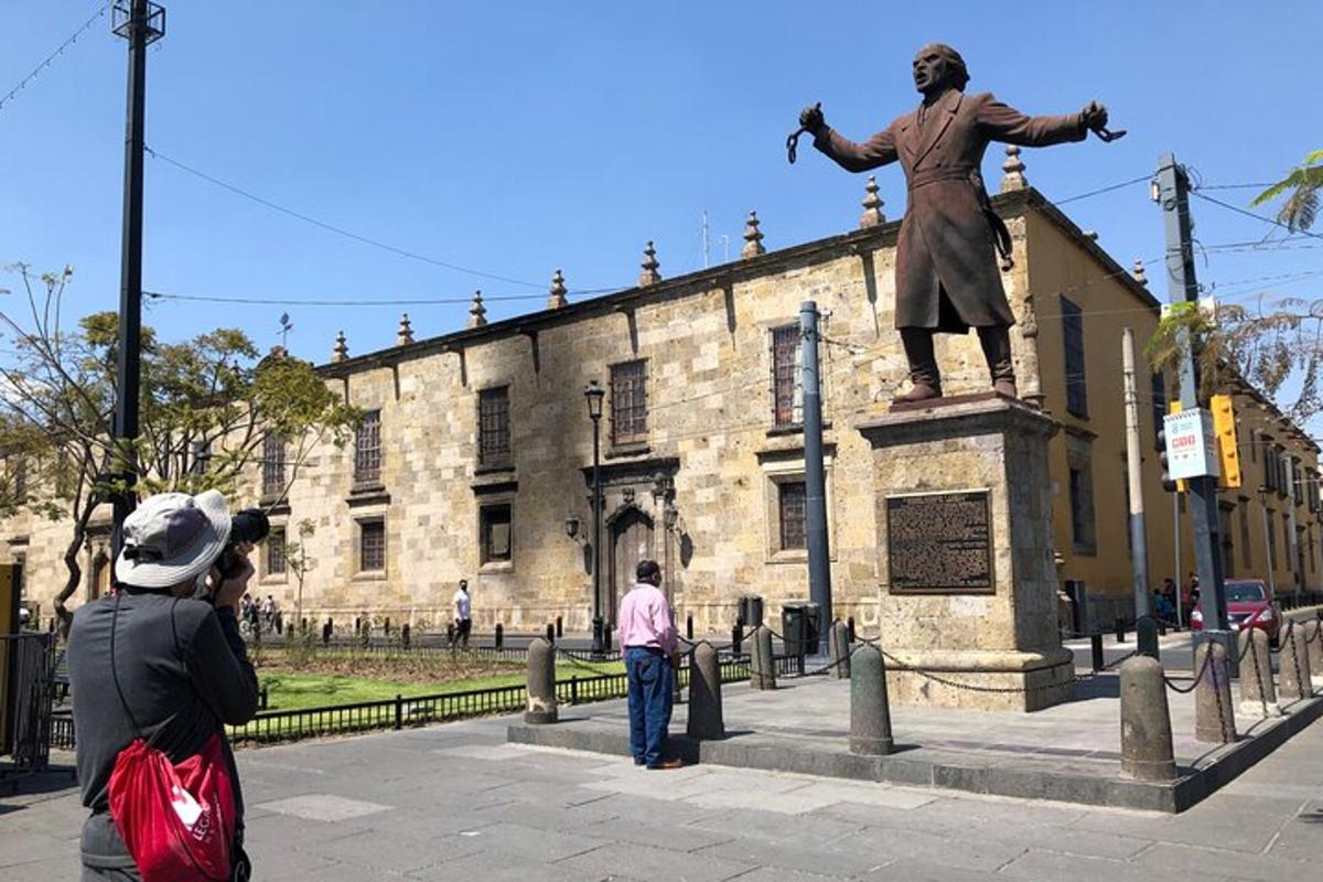 a man taking a picture of a statue in front of a building