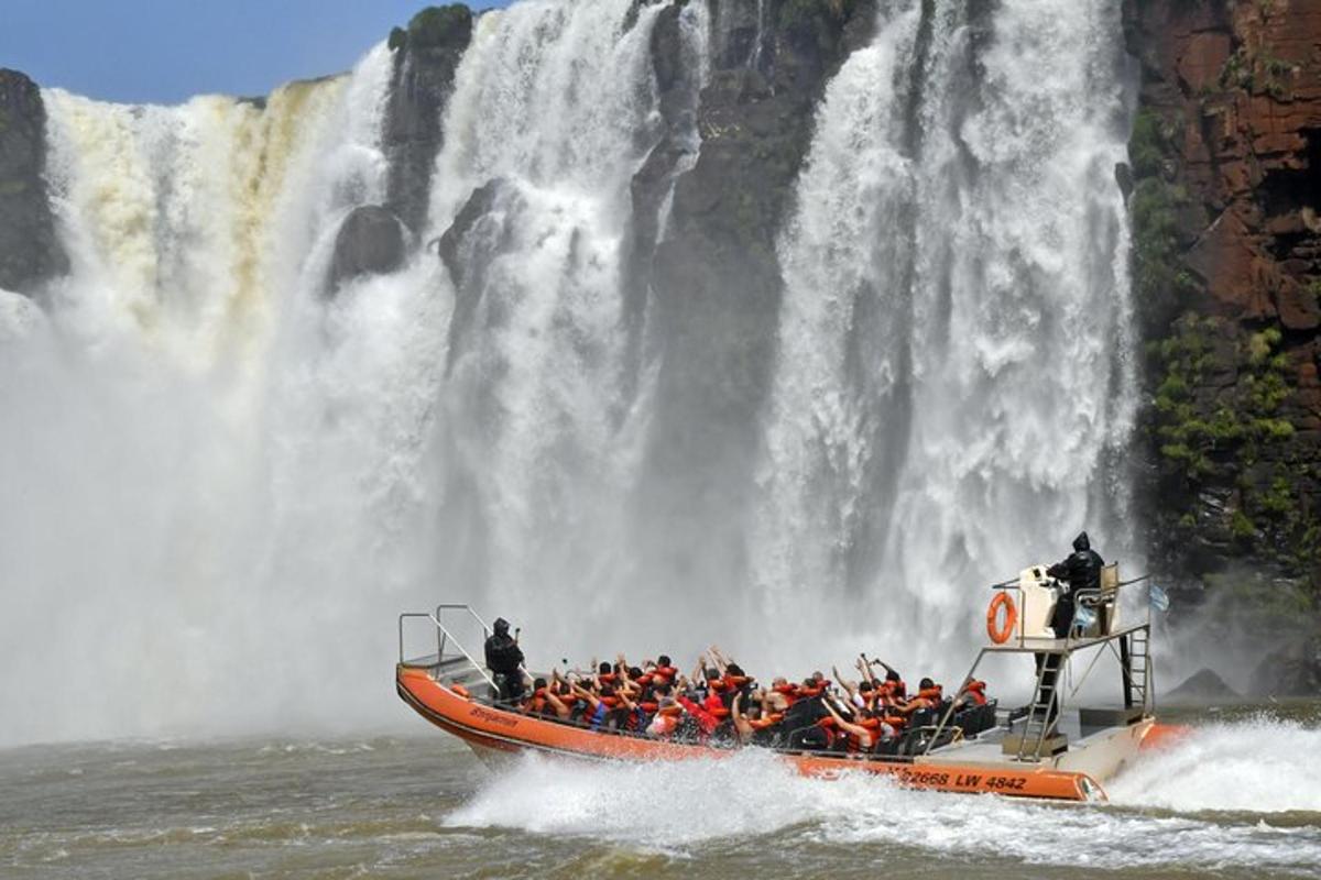 Un grupo de personas en un barco frente a una cascada.
