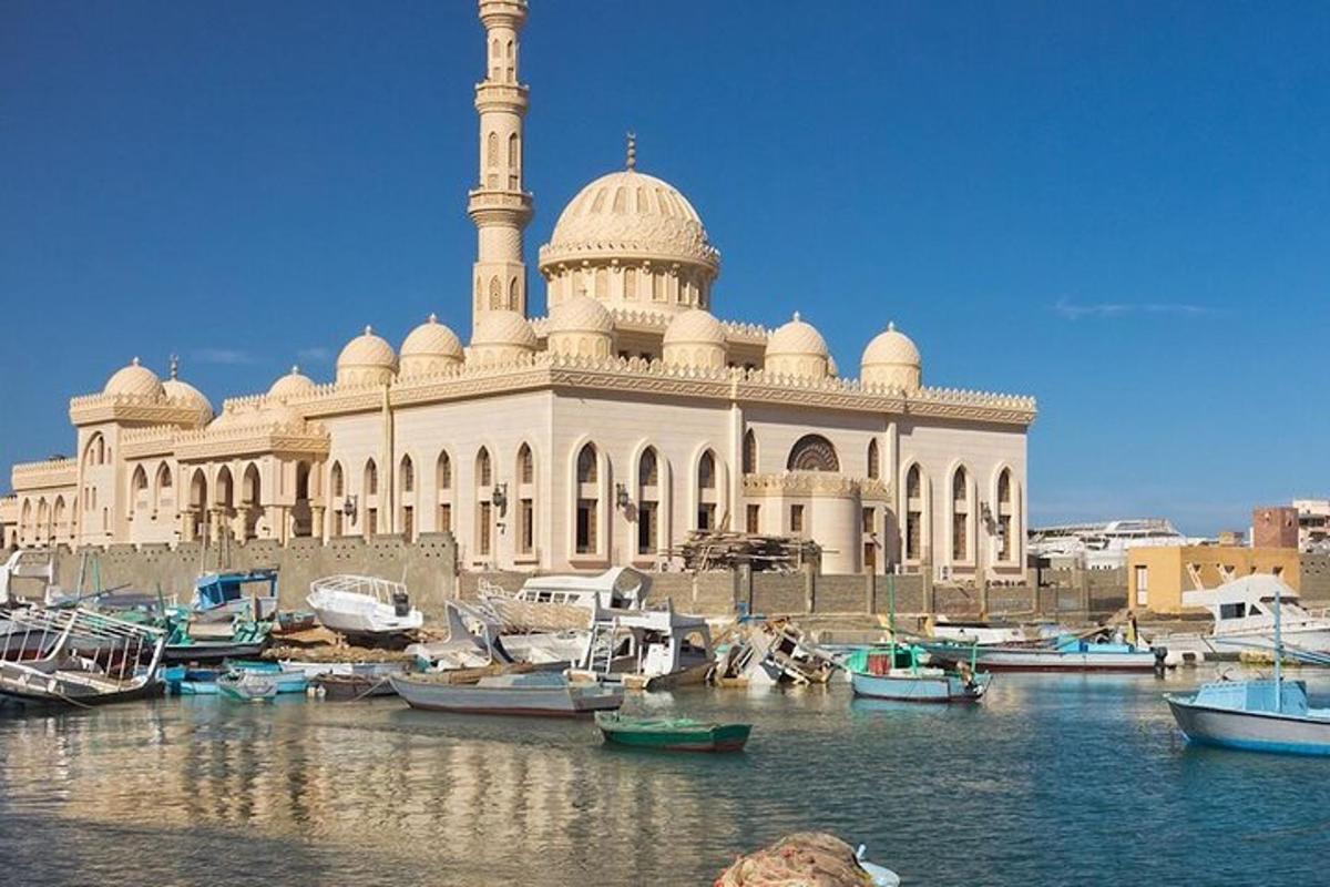 a large white building with a tower and boats in the water