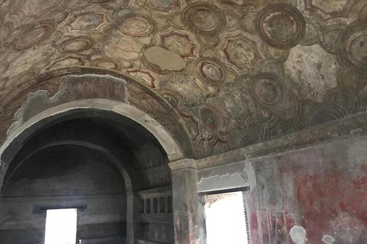 una stanza con un dipinto sul soffitto con due finestre