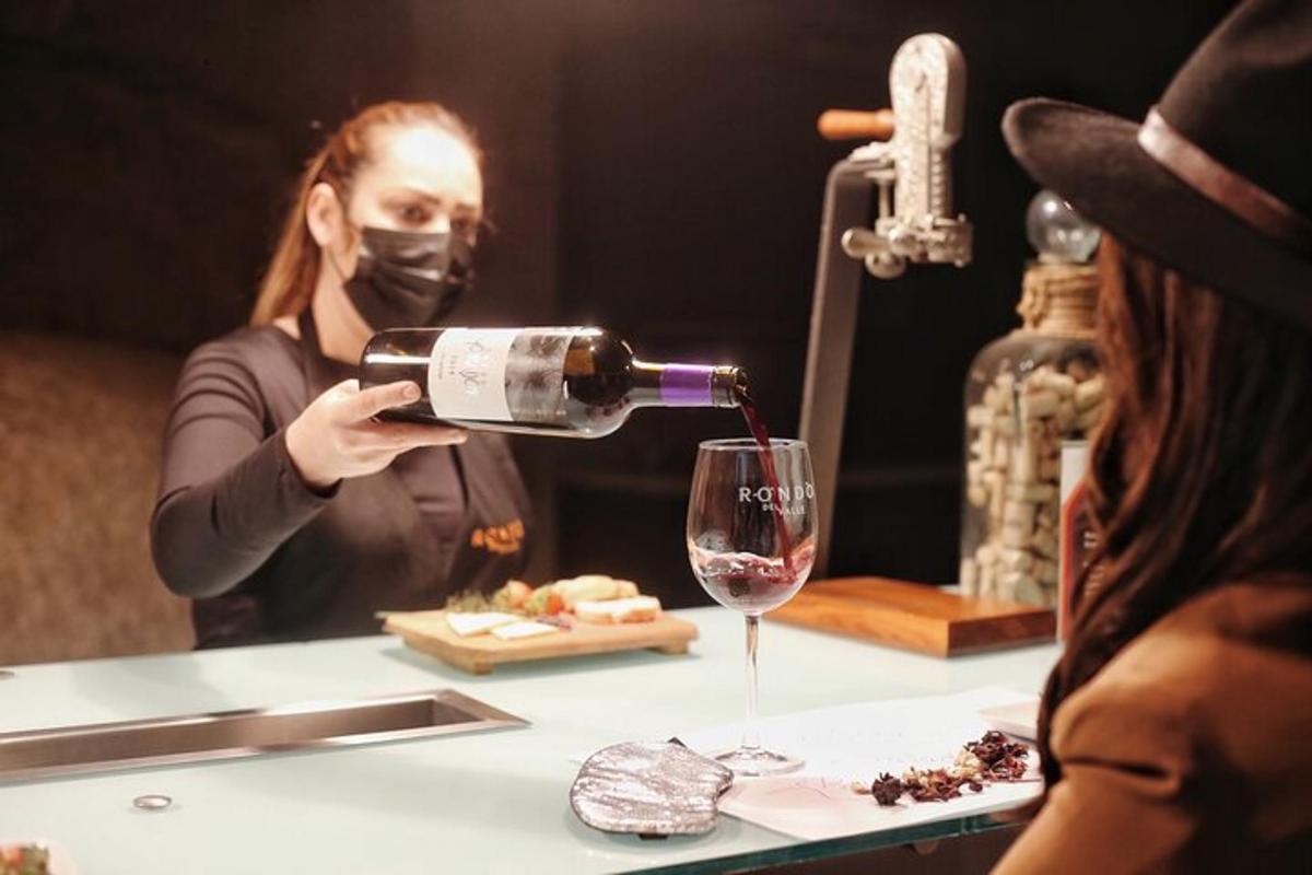 egy maszkos nő bort önt egy pohárba