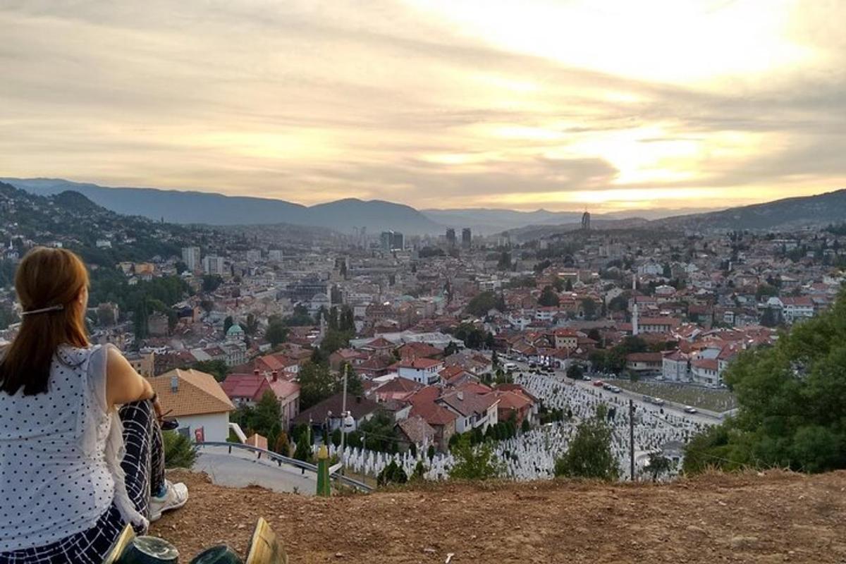 una donna seduta su una collina che guarda una città
