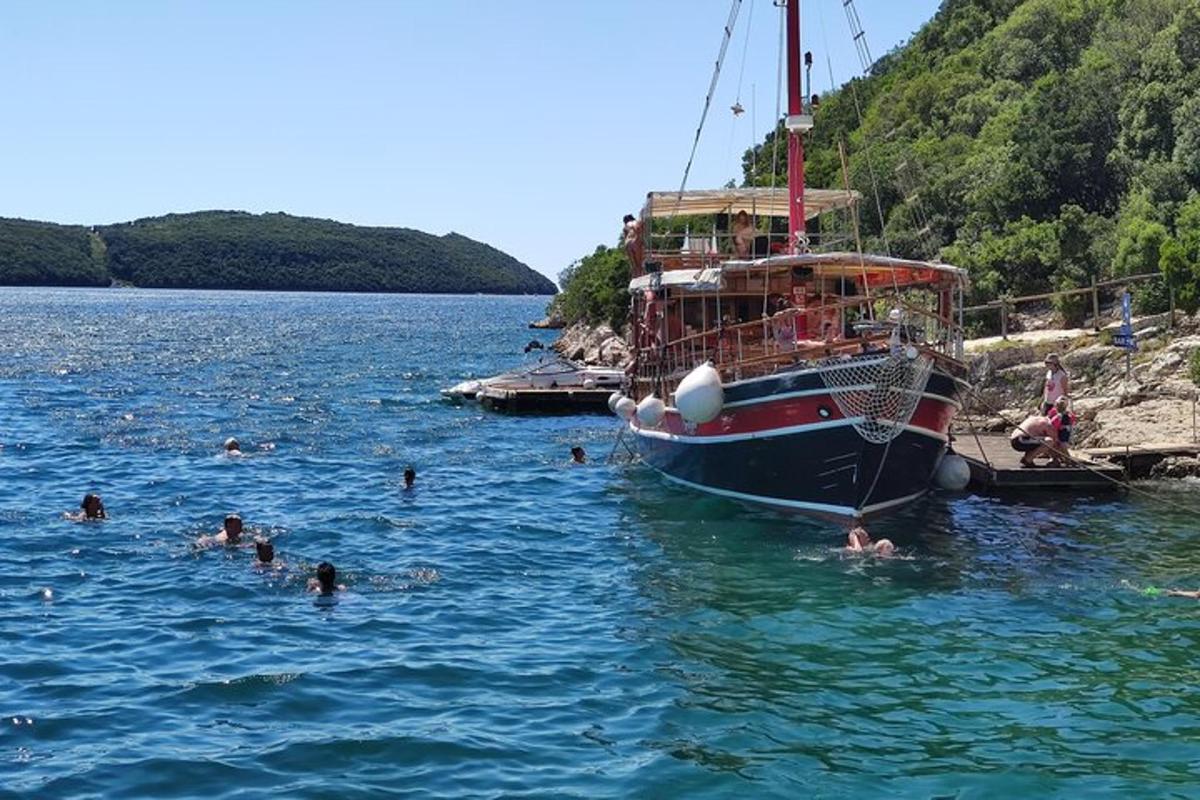 un gruppo di persone che nuotano nell'acqua accanto a una barca