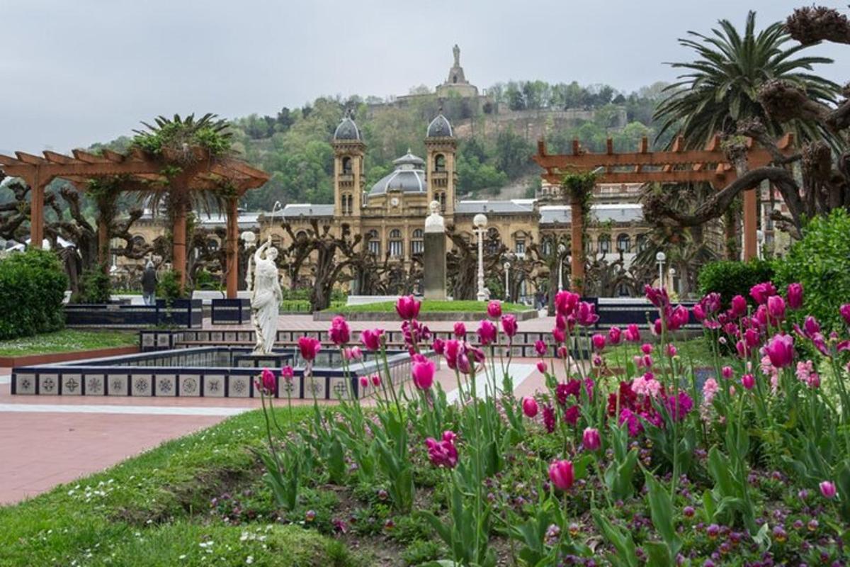 um parque com flores rosas em frente a um prédio