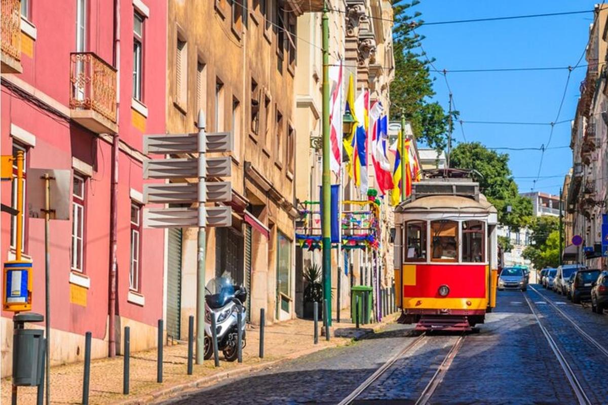a red and yellow tram on a street with flags