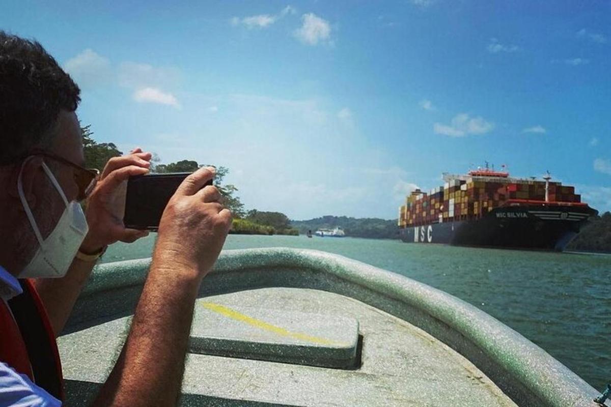 un bărbat care fotografiază o barcă mare pe apă