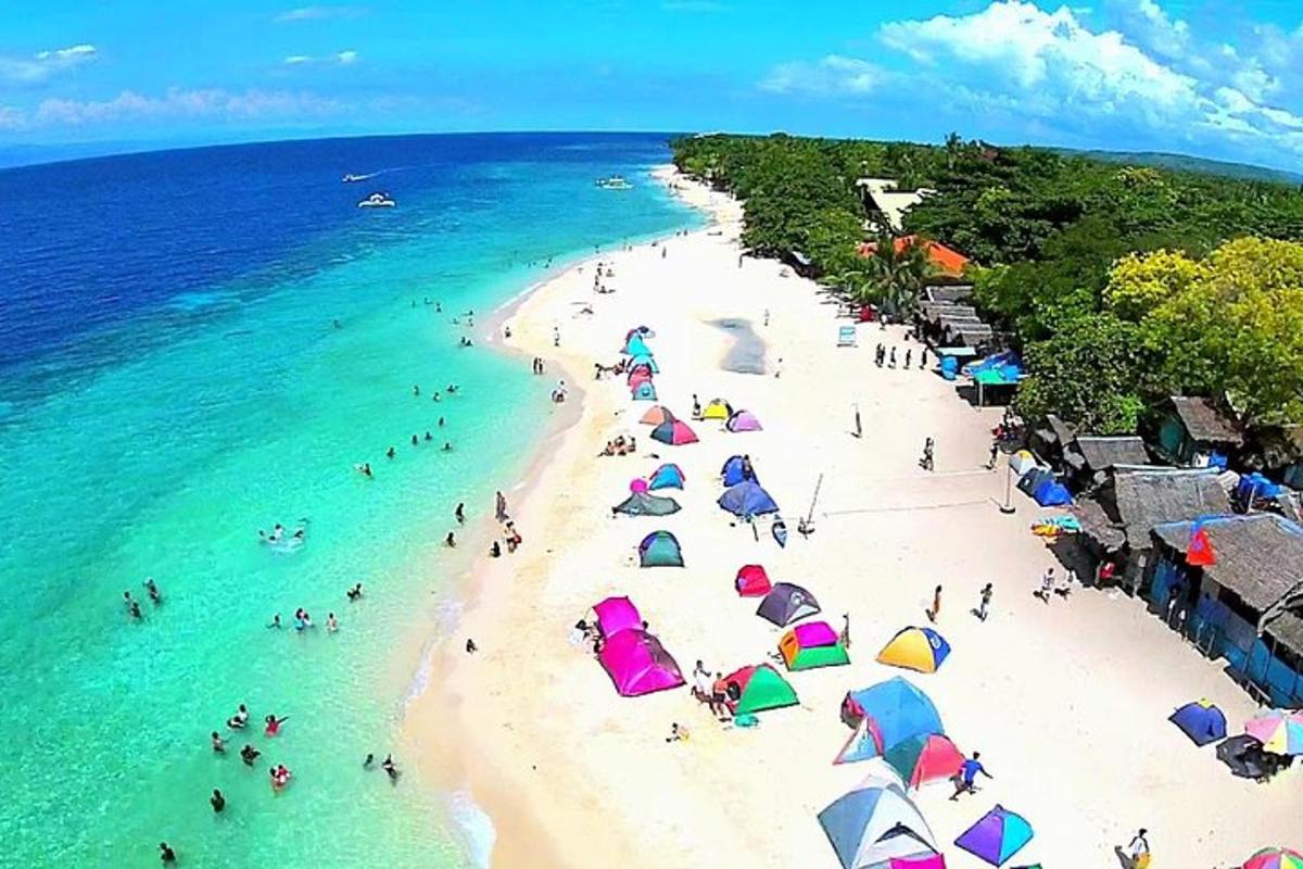 sekumpulan orang di pantai dengan payung