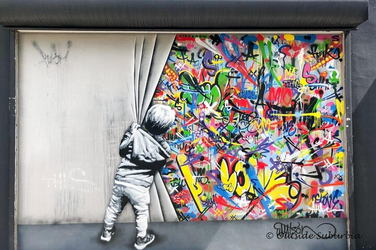 Mladý chlapec maluje zeď graffiti