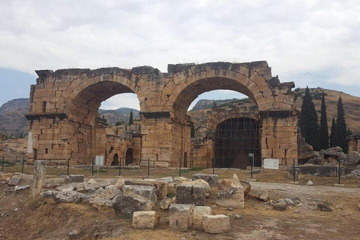 an old stone building with two arches on a hill