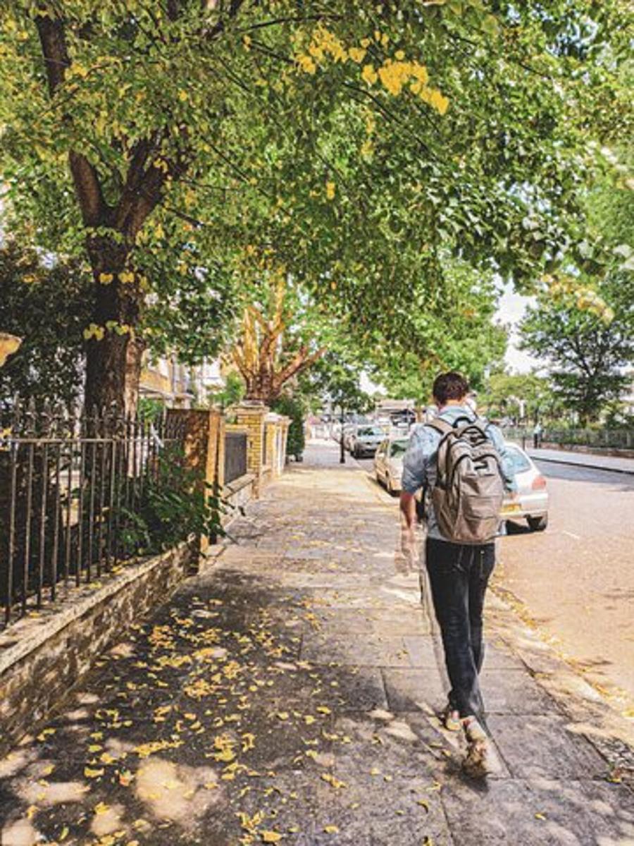 a man walking down a street with a backpack