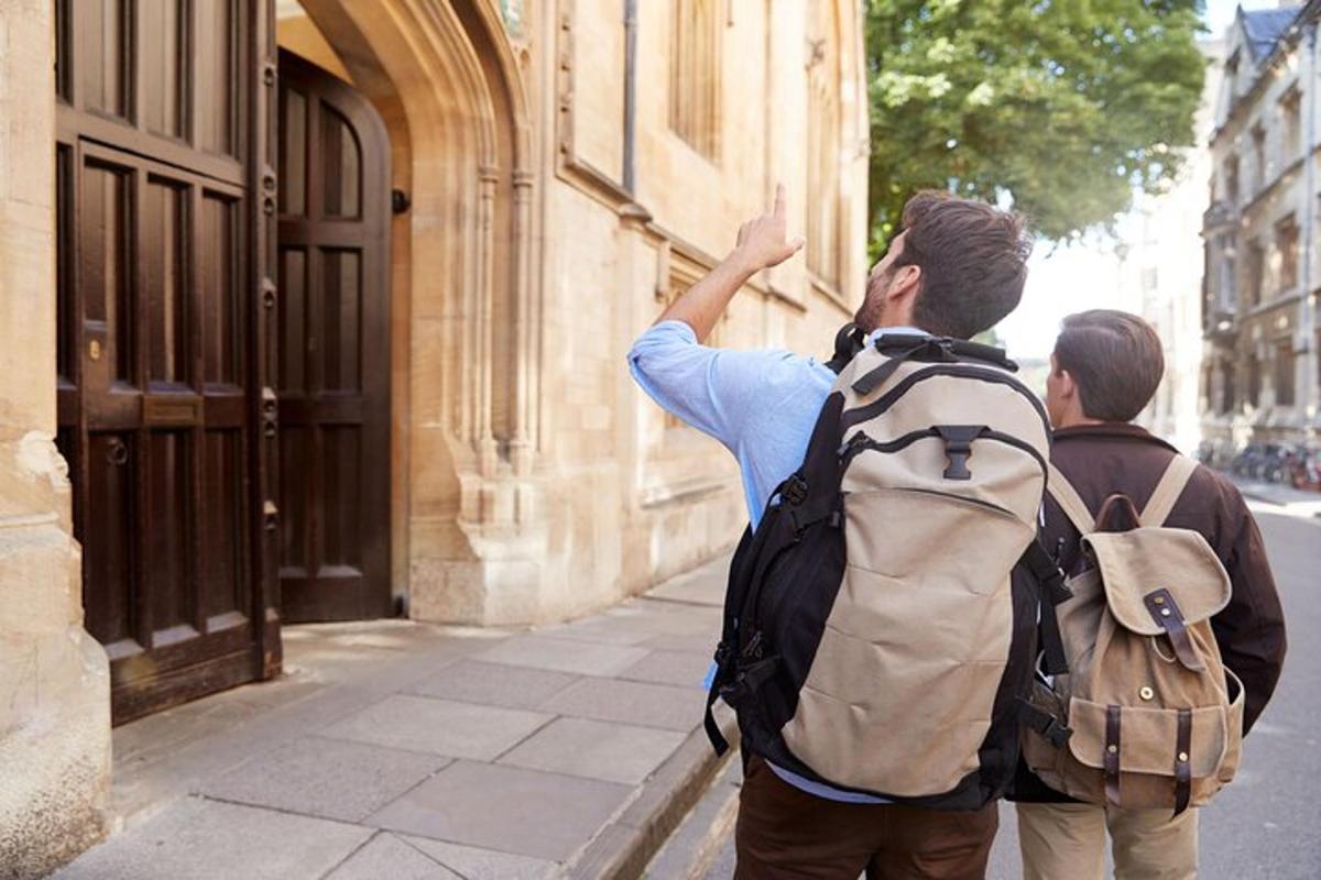 a man with a backpack pointing at a building