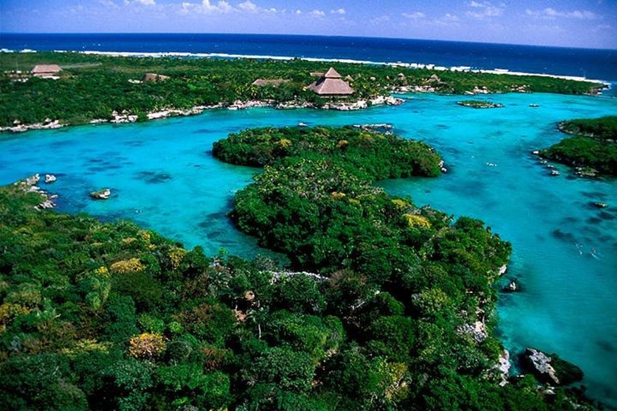 an aerial view of an island with blue water and trees