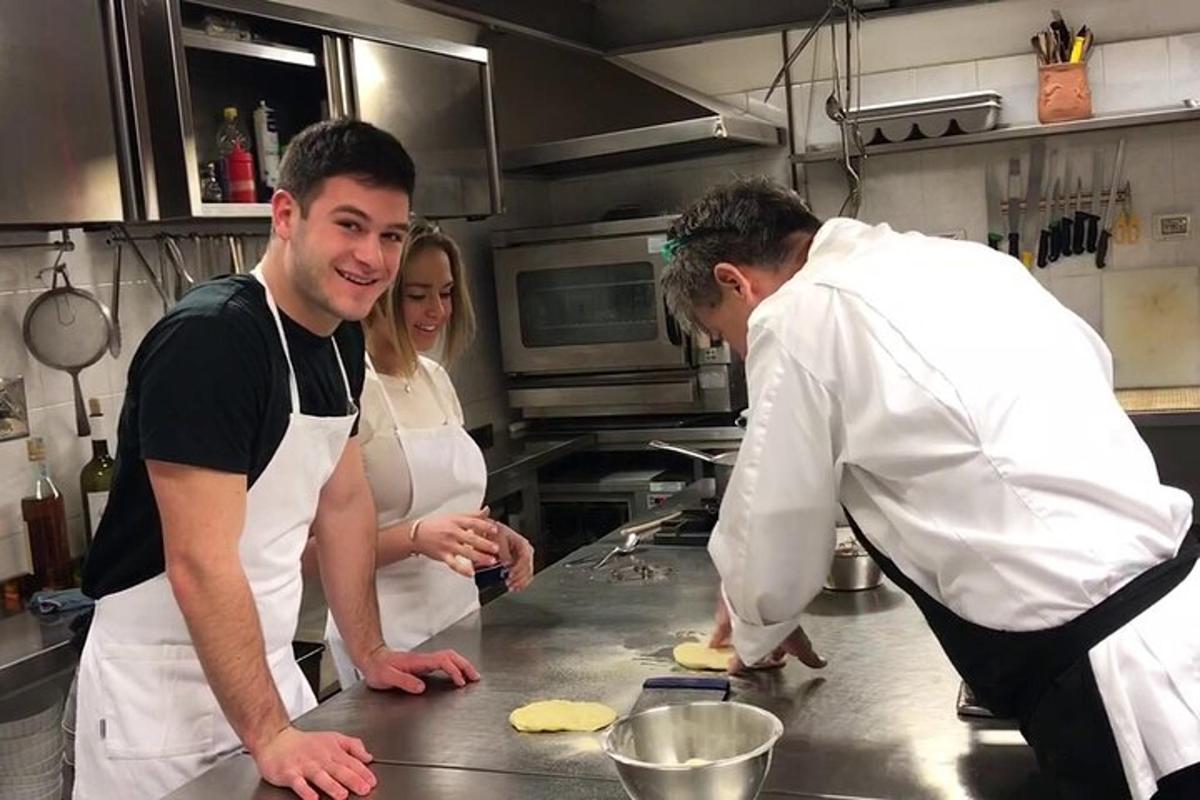 due uomini e una donna in cucina che preparano il cibo