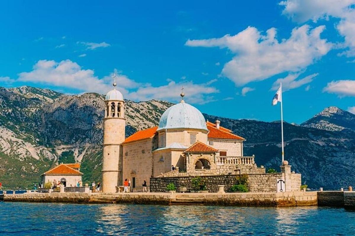 a building on the water with mountains in the background