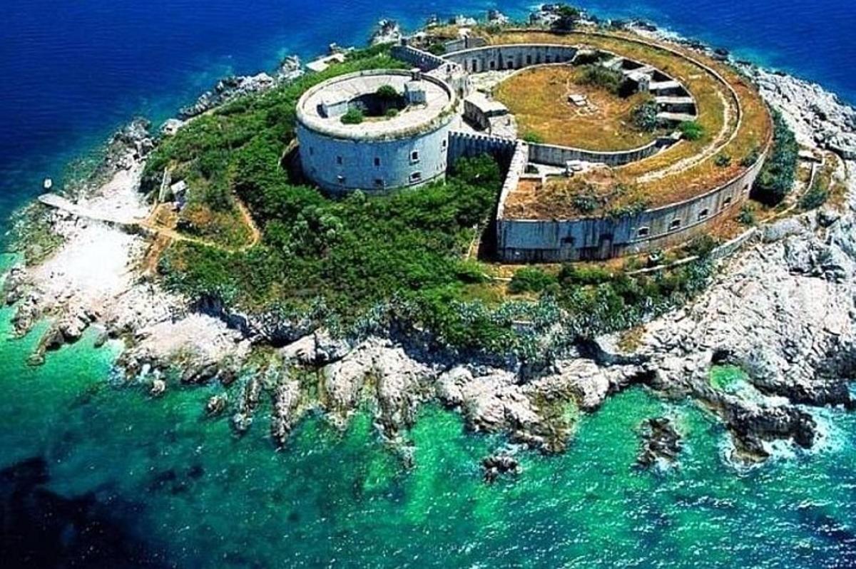an island in the ocean with a building on it