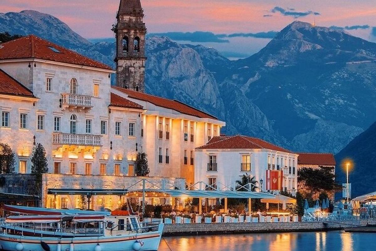 a building with a clock tower and a boat in the water