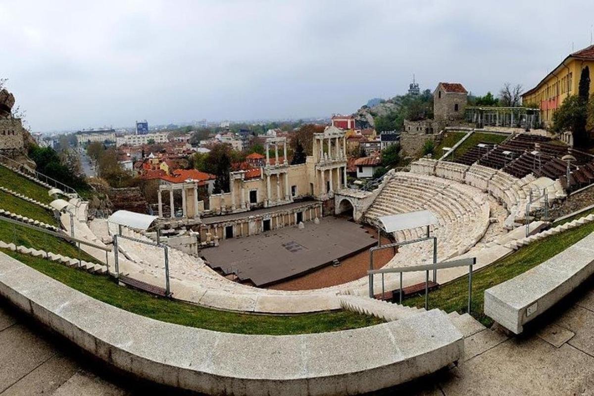 an amphitheater with seats and a city in the background