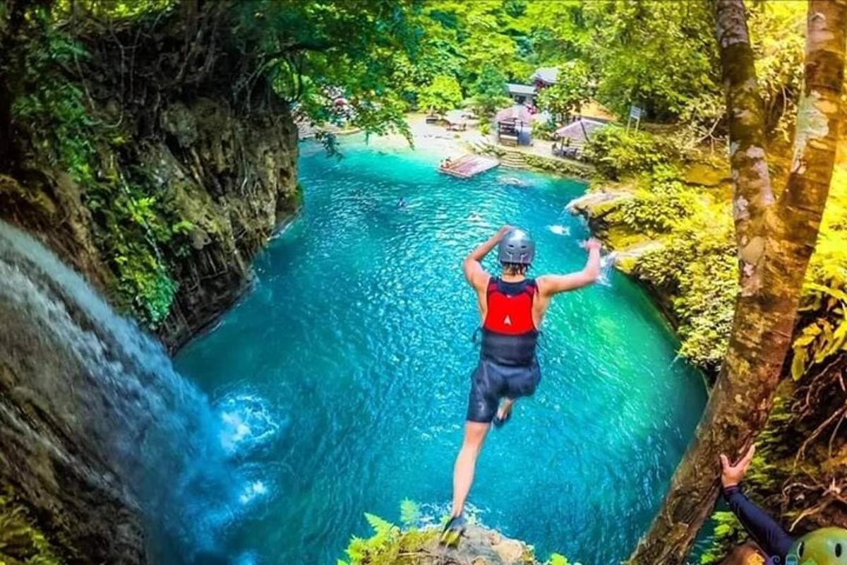 člověk skákající z útesu do řeky